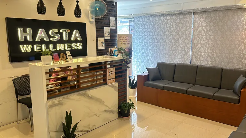 Reception at Hasta Wellness: the illuminated clinic sign, the front desk and the waiting area